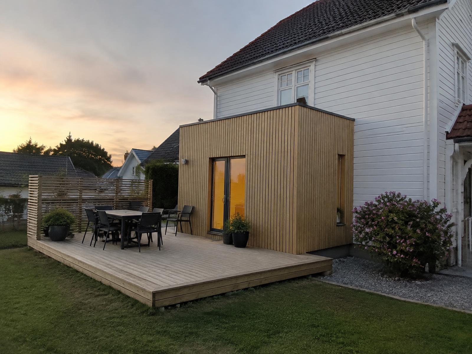 Tilbygg med naturleg trekledning og ny terrasse